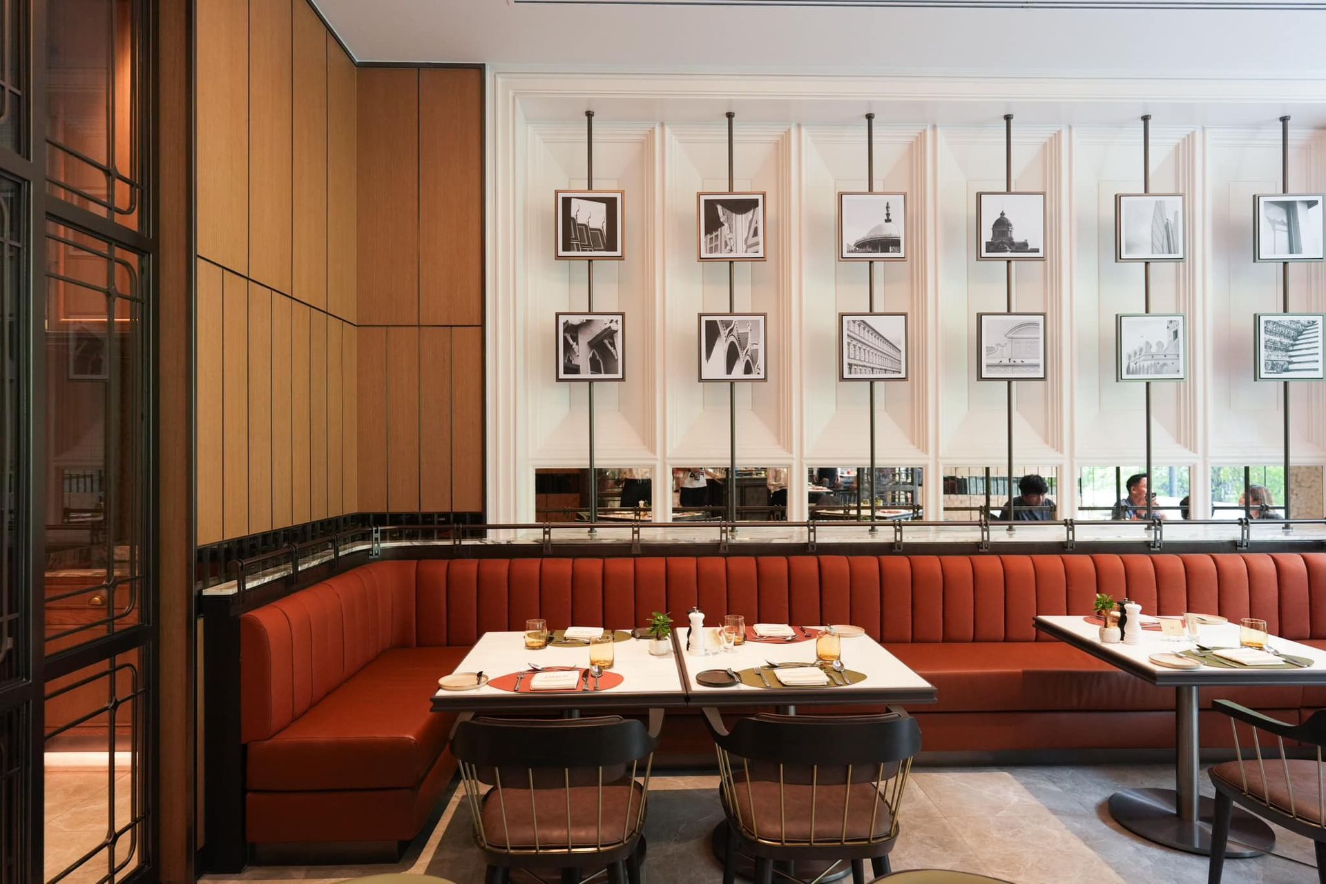 A restaurant with tables and chairs and a red couch.