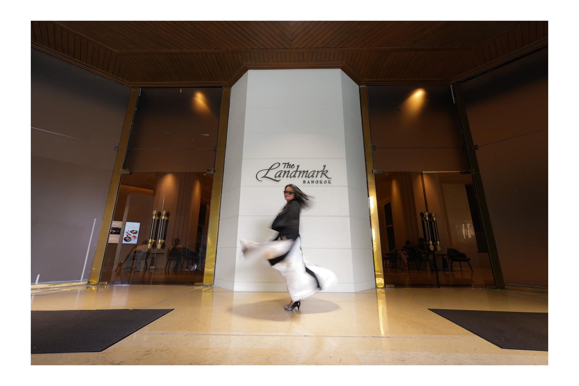 A woman is dancing in front of a large building.