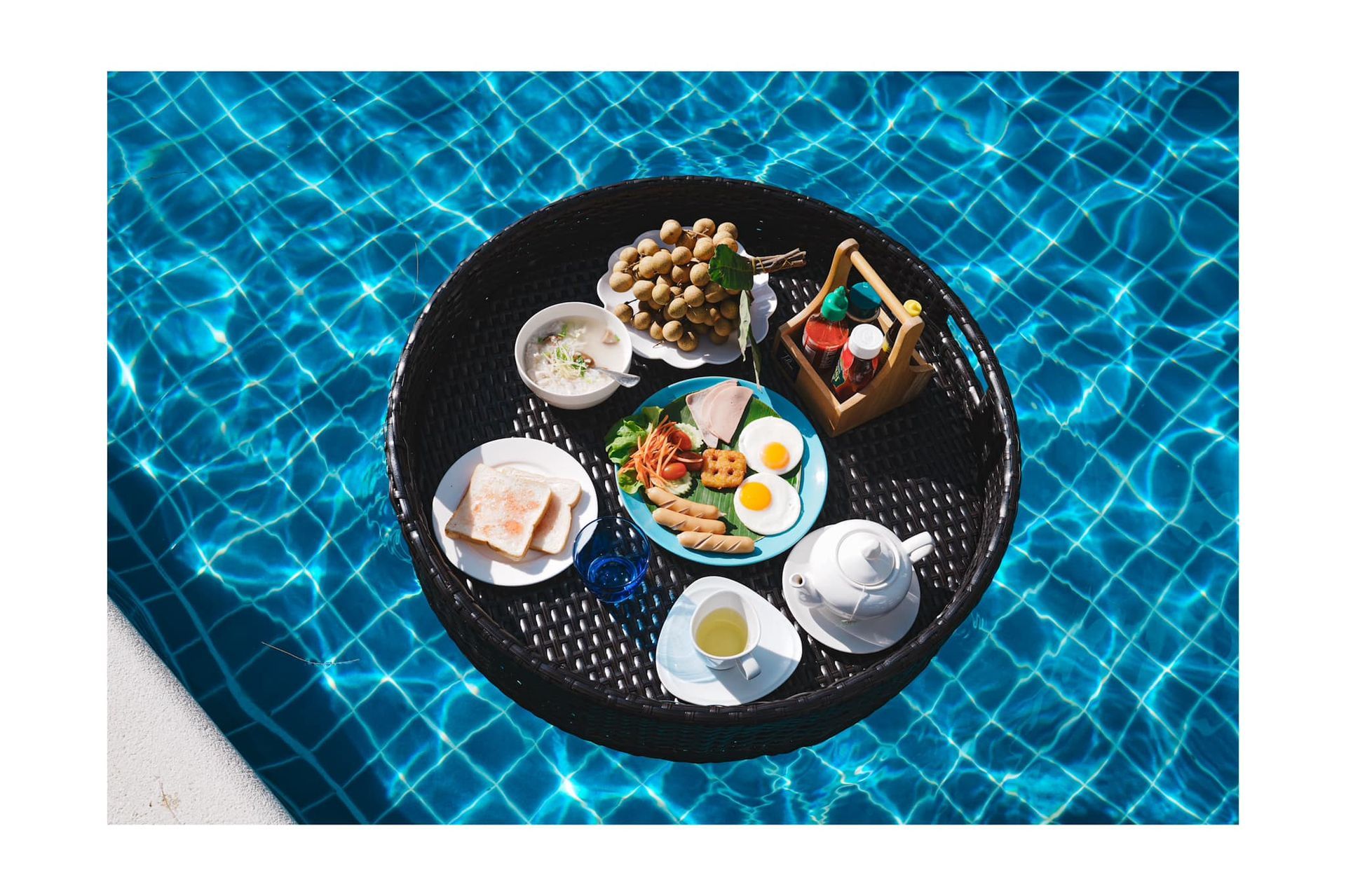 A tray of food is floating in a swimming pool.
