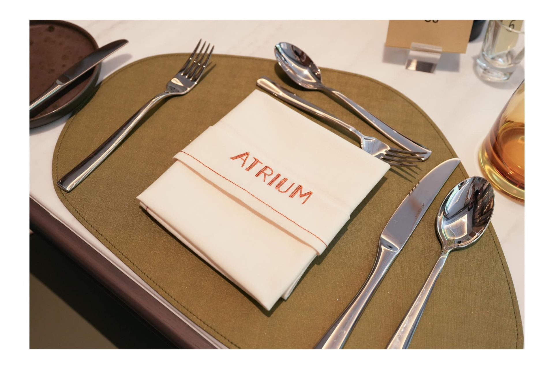A napkin with the word atrium embroidered on it