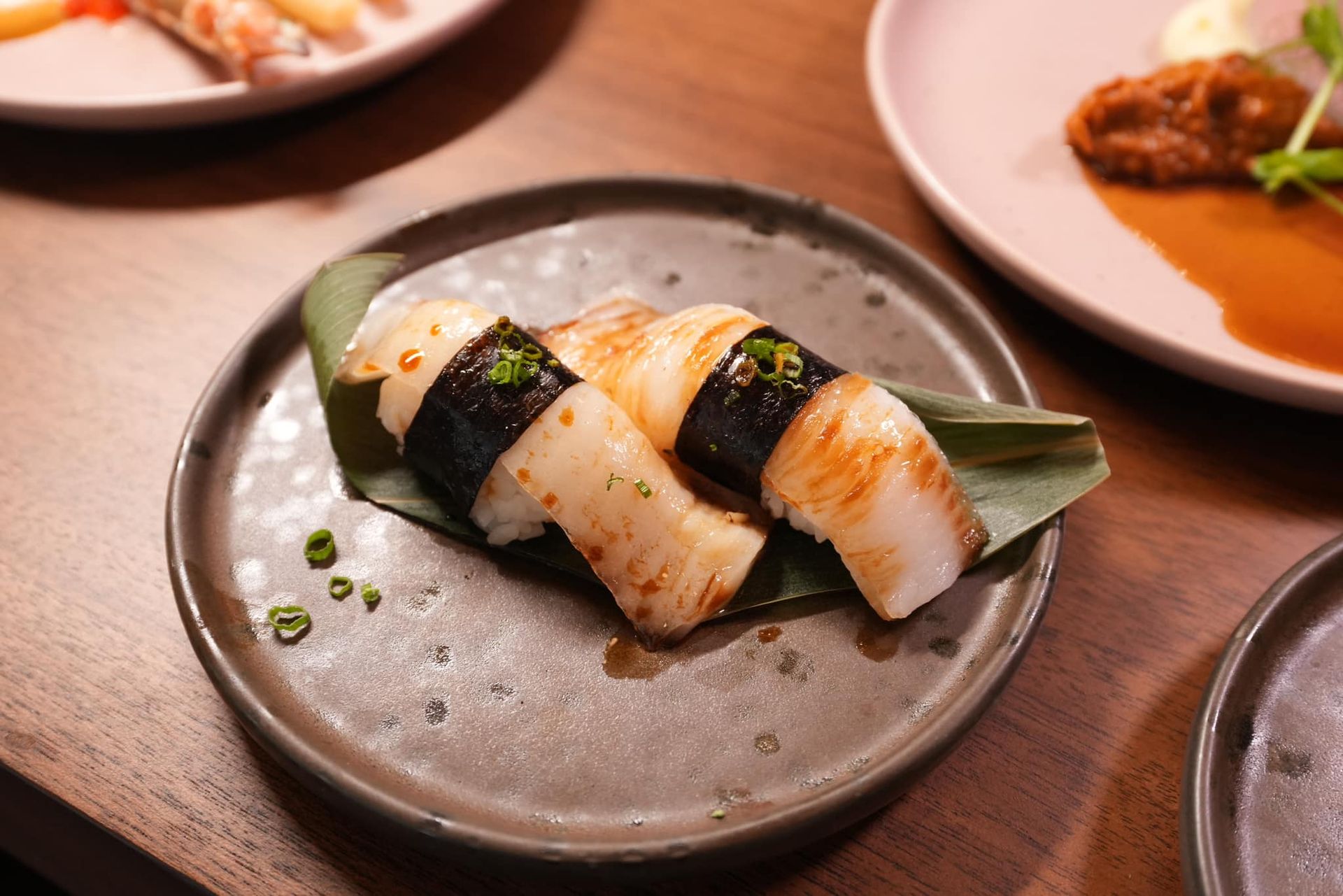 A close up of a plate of sushi on a table.