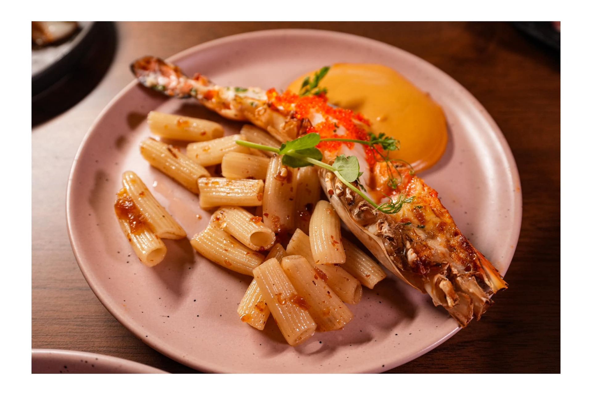 A plate of pasta and lobster on a table  at Atrium Restaurant.