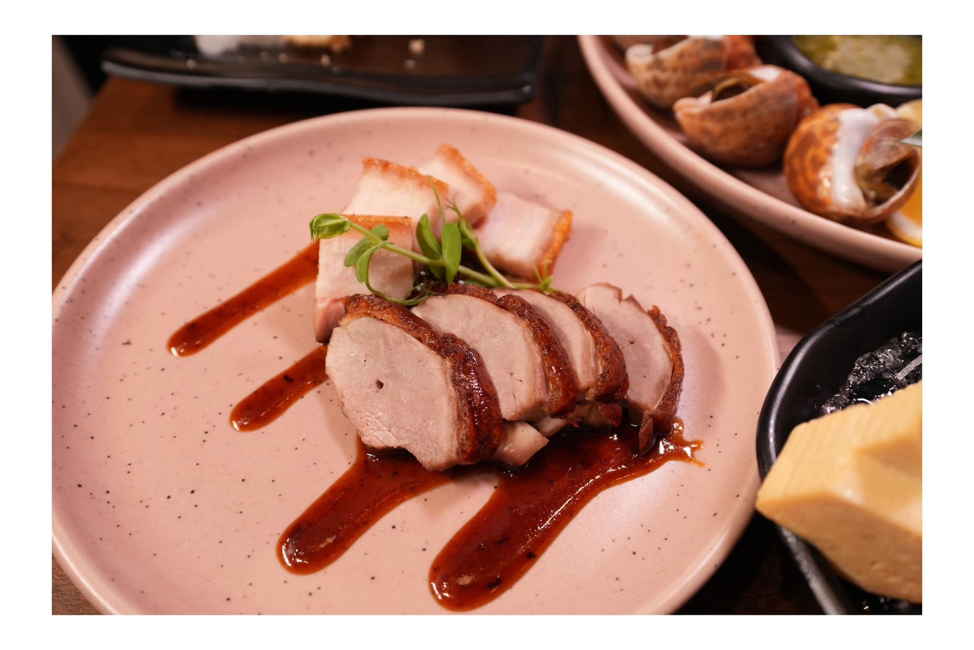 A close up of a plate of food with meat and sauce on a table.