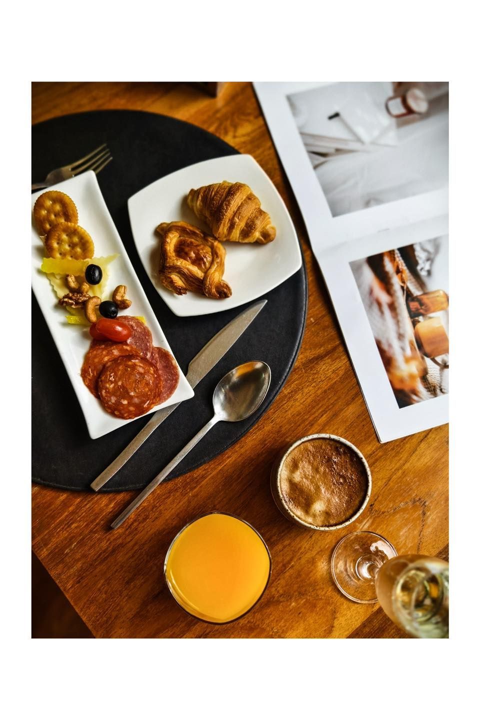 A wooden table topped with plates of food and a cup of orange juice