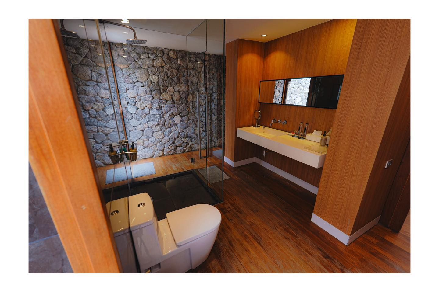 A bathroom with a toilet , sink and shower.