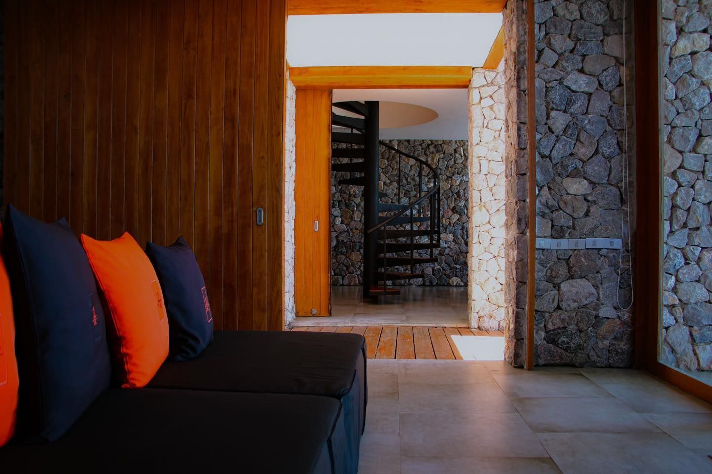 A living room with a spiral staircase in the background