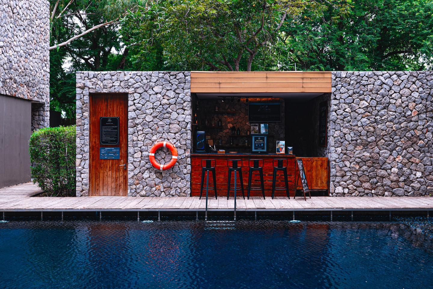 A stone building with a bar next to a swimming pool.