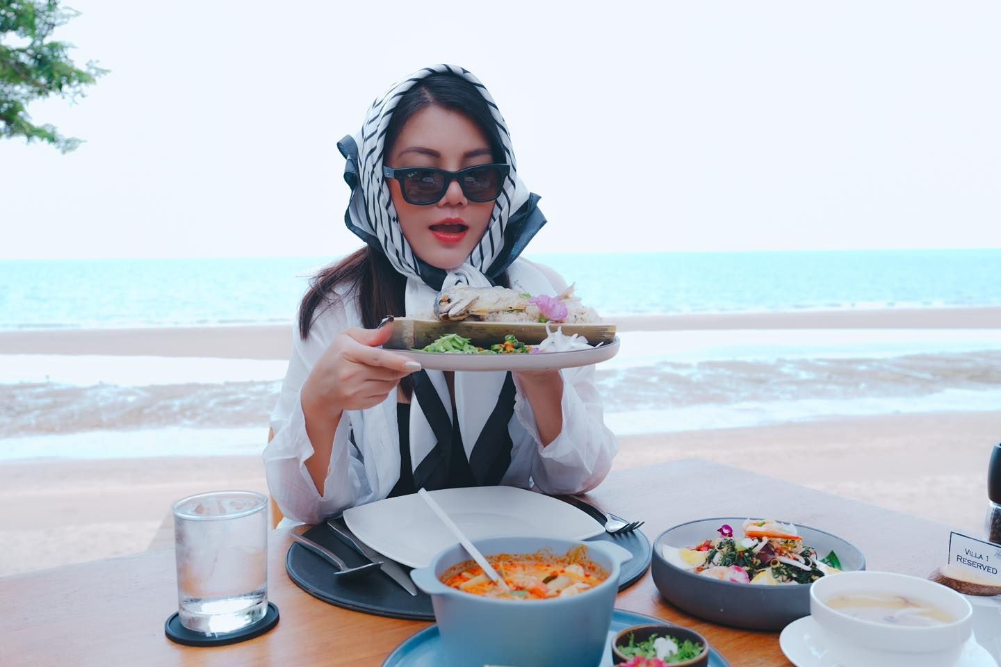 A woman is sitting at a table eating a plate of food.