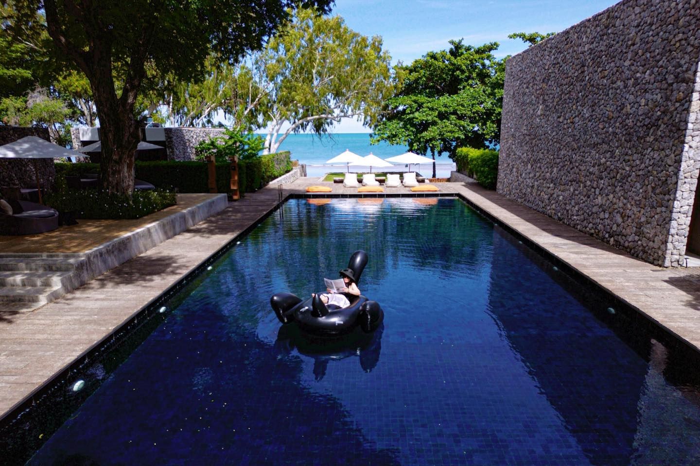 A person is floating on a raft in a swimming pool.