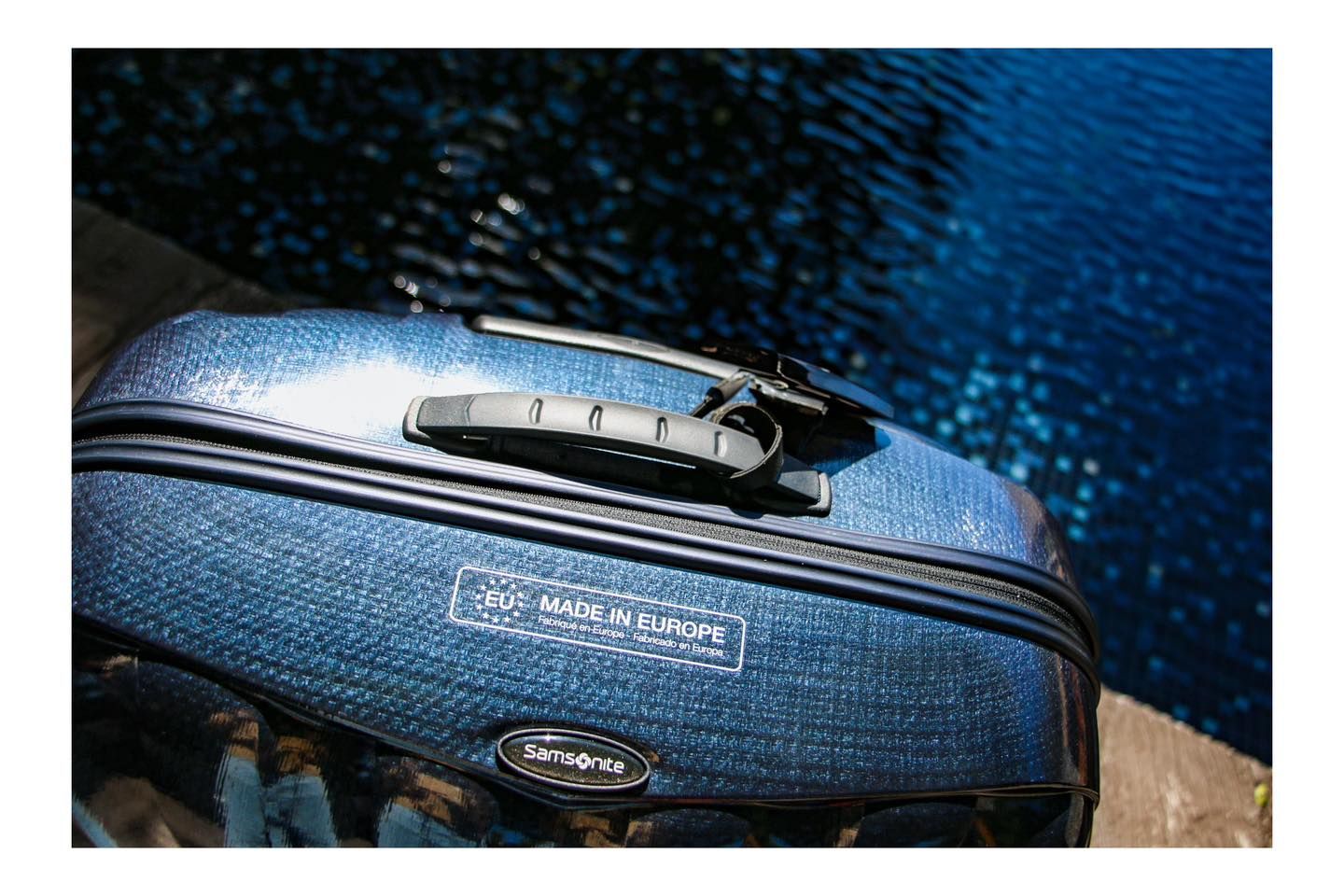 A close up of a blue samsonite suitcase with a lock on it.