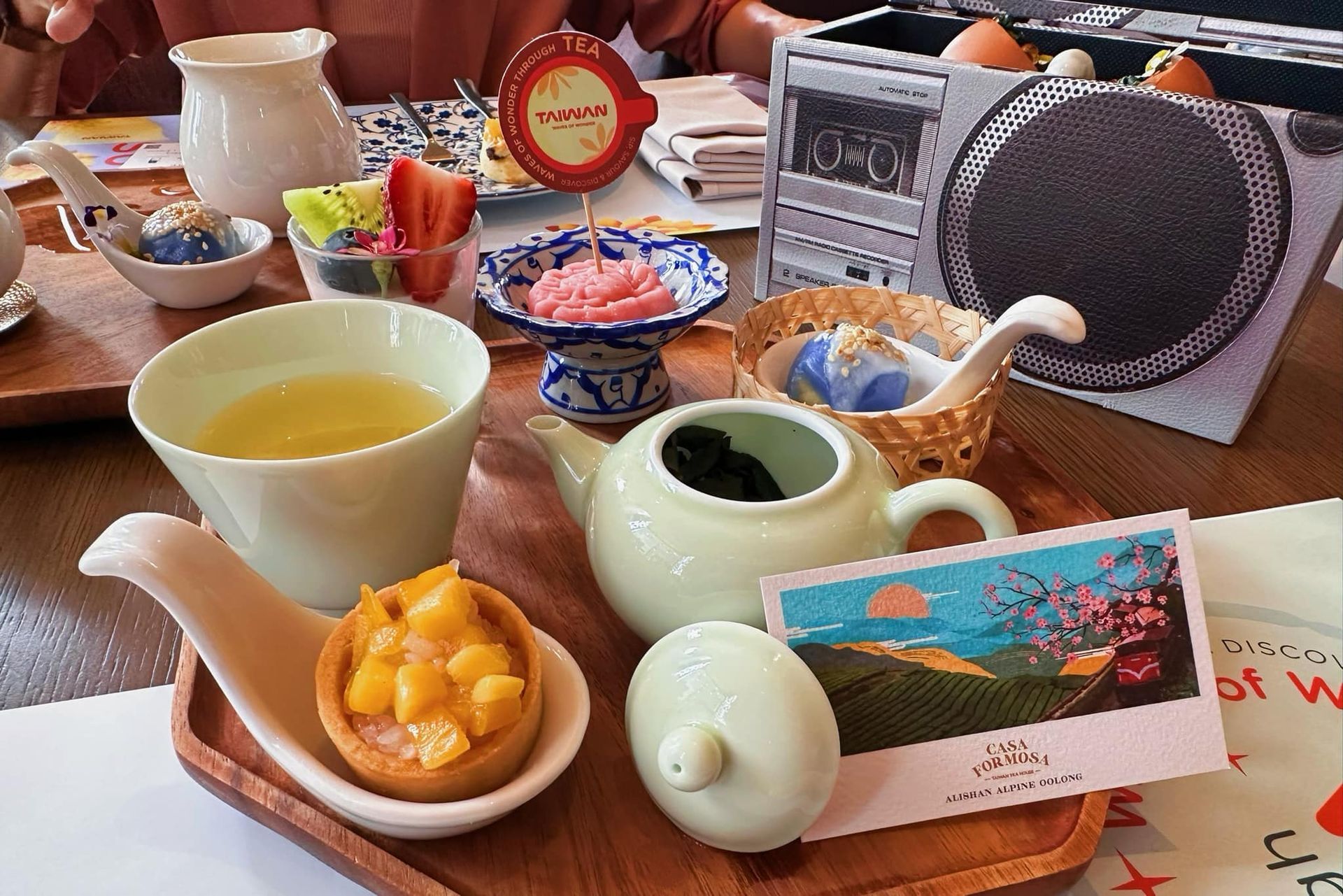 A wooden tray with a teapot and cups of tea on it