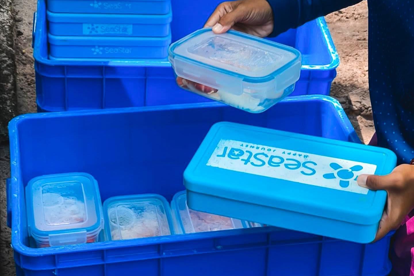 A person is holding a blue container that says Seastar on it