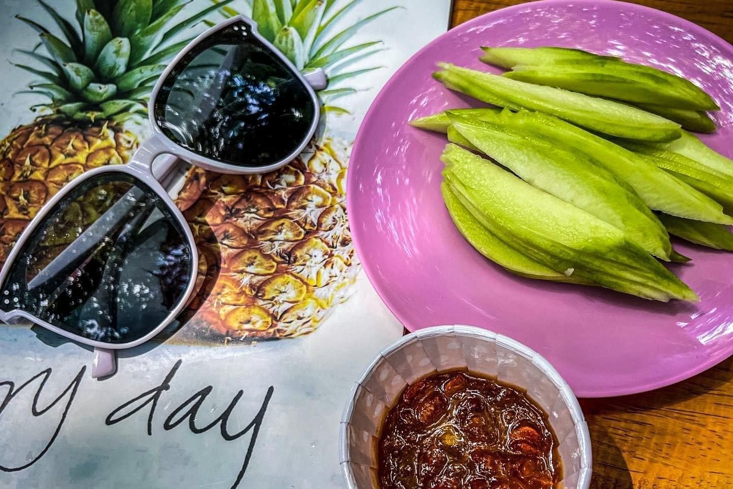 A pair of sunglasses sitting on top of a napkin next to a plate of food.
