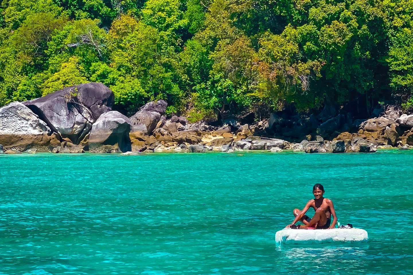 A man is sitting on a raft in the ocean