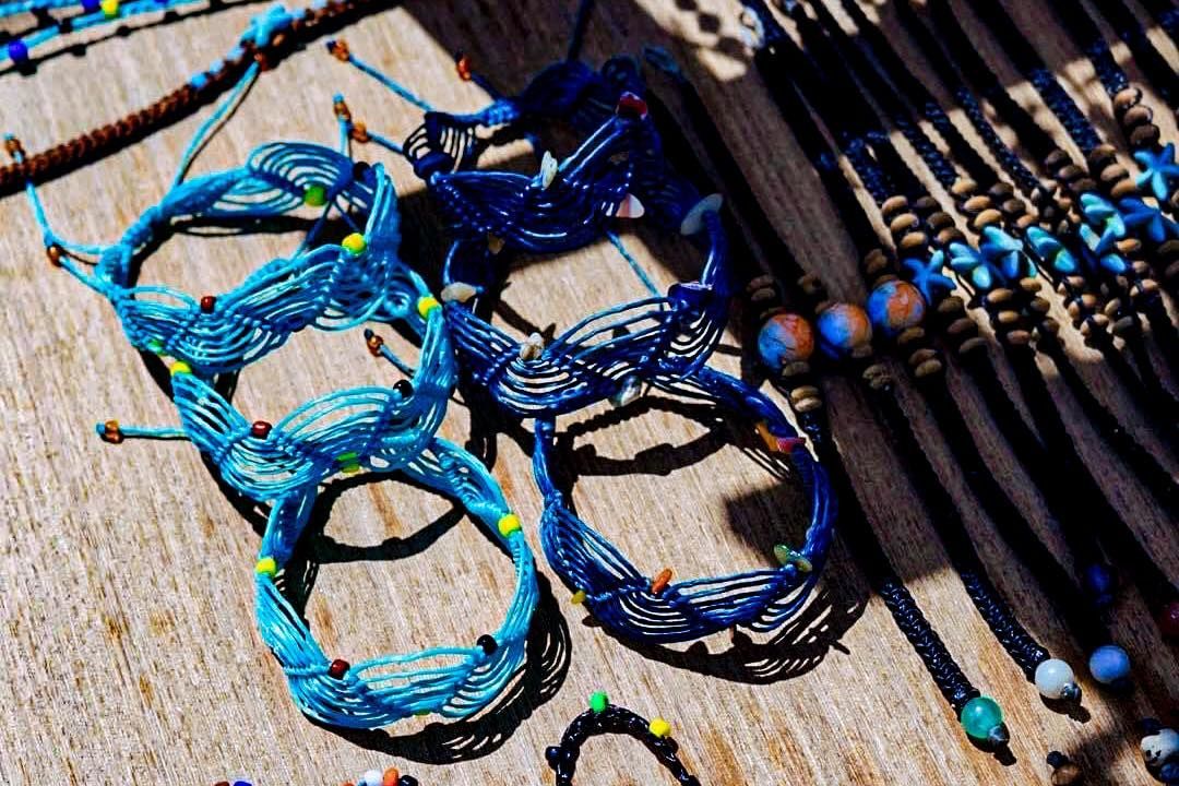 A bunch of blue bracelets are sitting on a table.