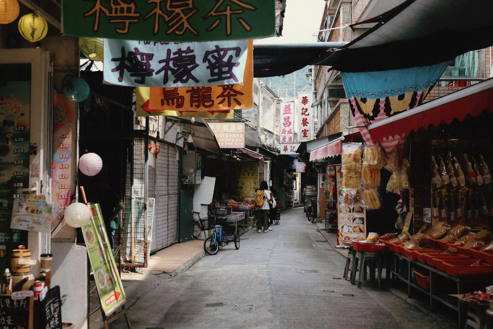 A narrow street with a sign that says ' chinese ' on it