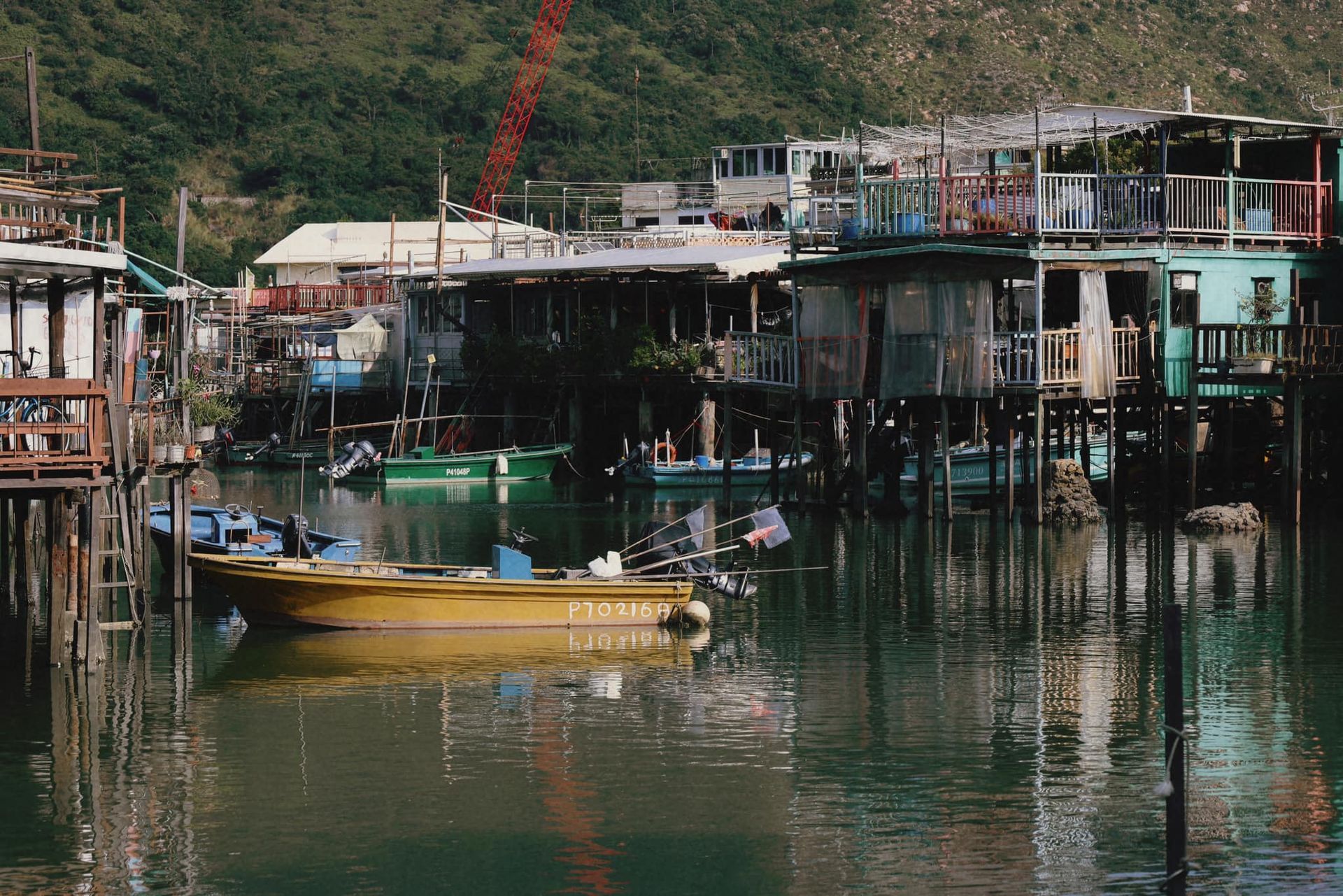 A yellow boat is floating in a body of water in tai o fishing village