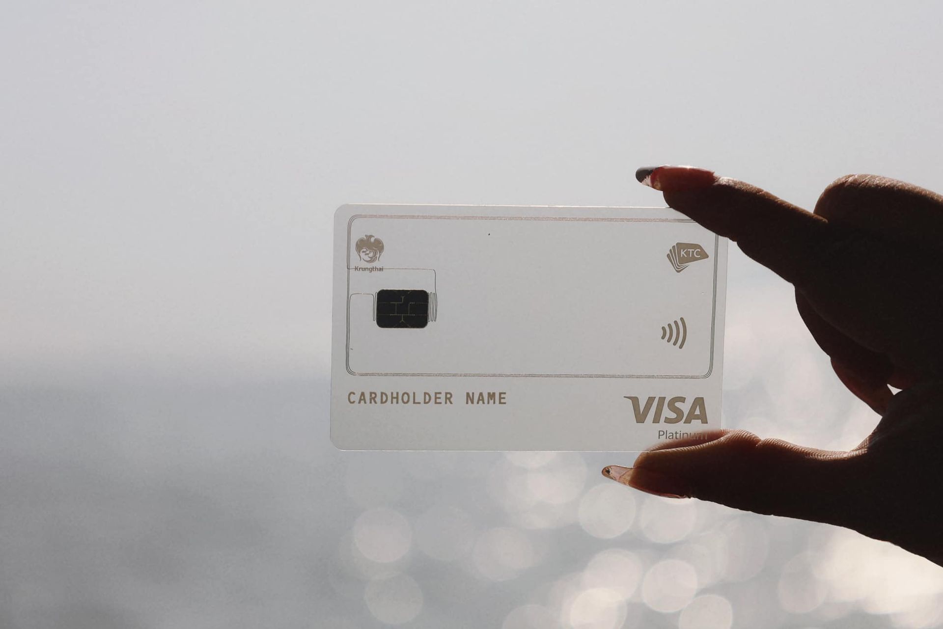 A person is holding a clear KTC visa card in their hand.