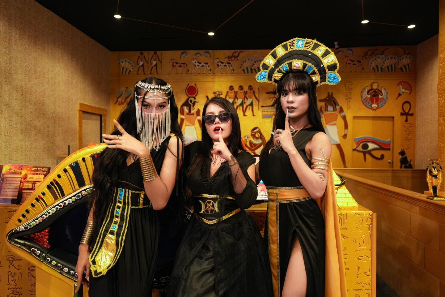 Three women dressed in egyptian costumes are posing for a picture.