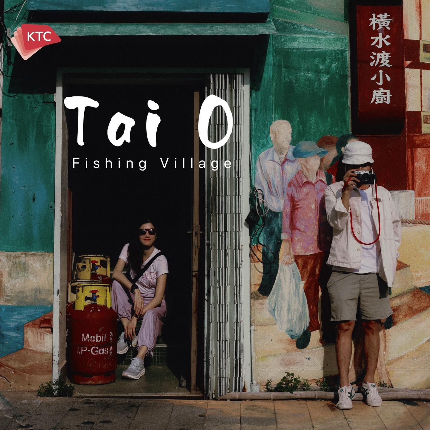A man taking a picture in front of a tai o fishing village