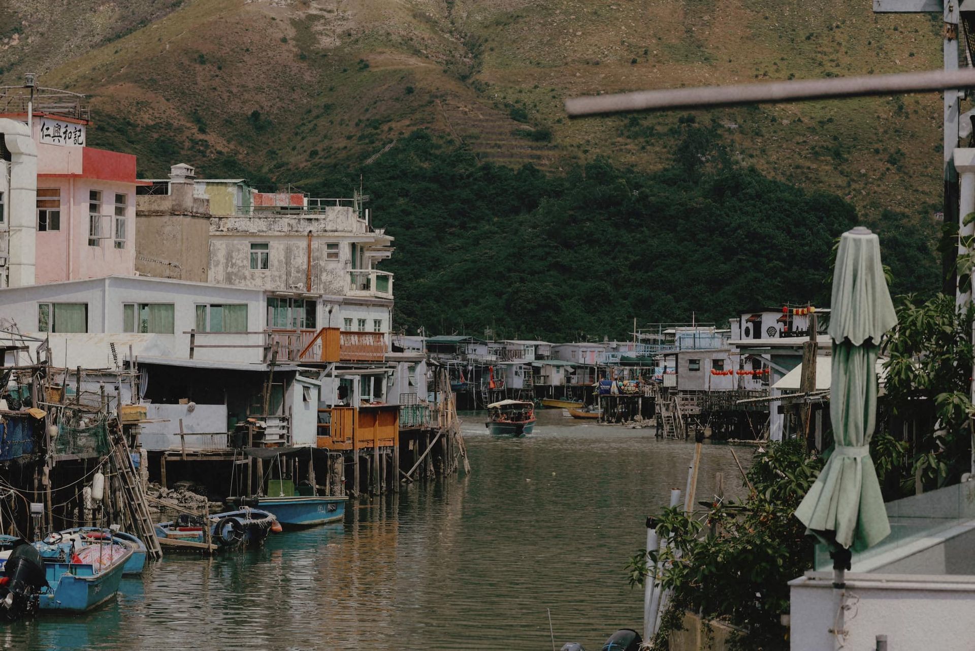 A row of houses sit on stilts overlooking a body of water in Taiwan