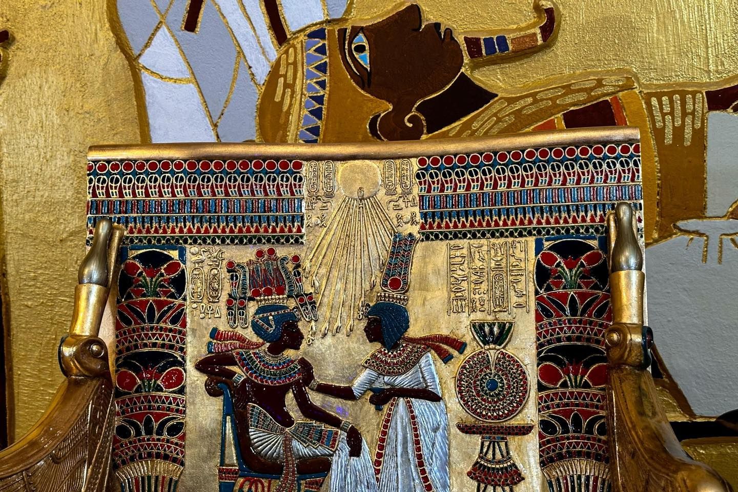 A gold chair with a picture of a man and woman on it