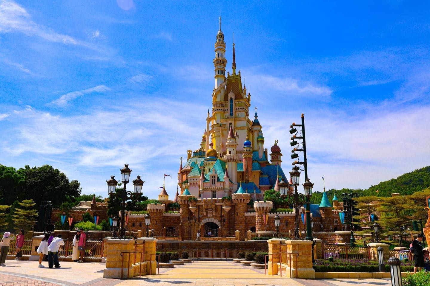 A large Disney castle with a fountain in front of it