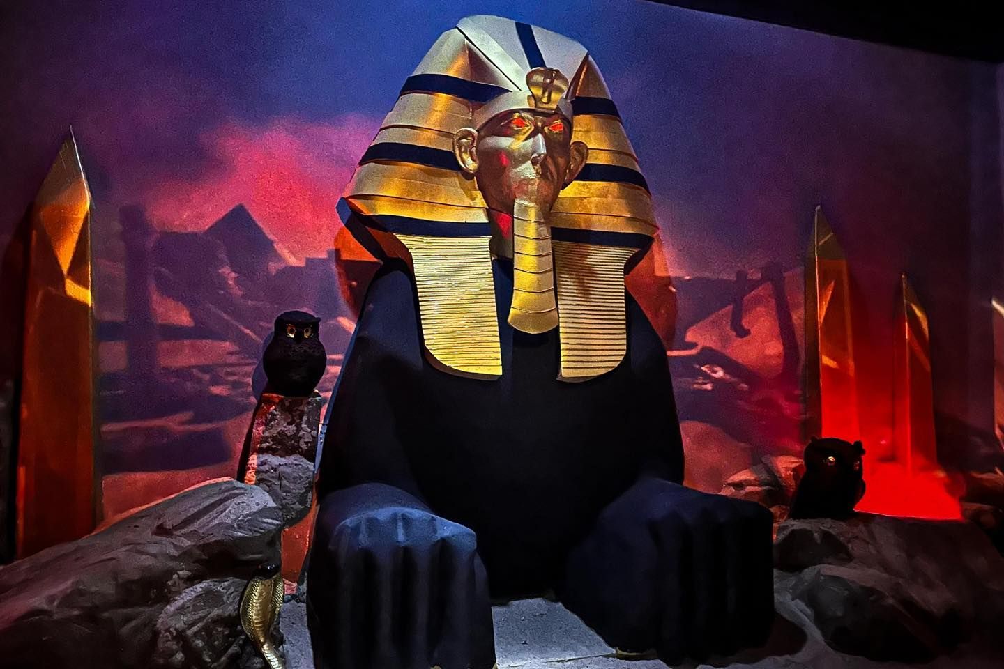 A statue of a sphinx with a pyramid in the background