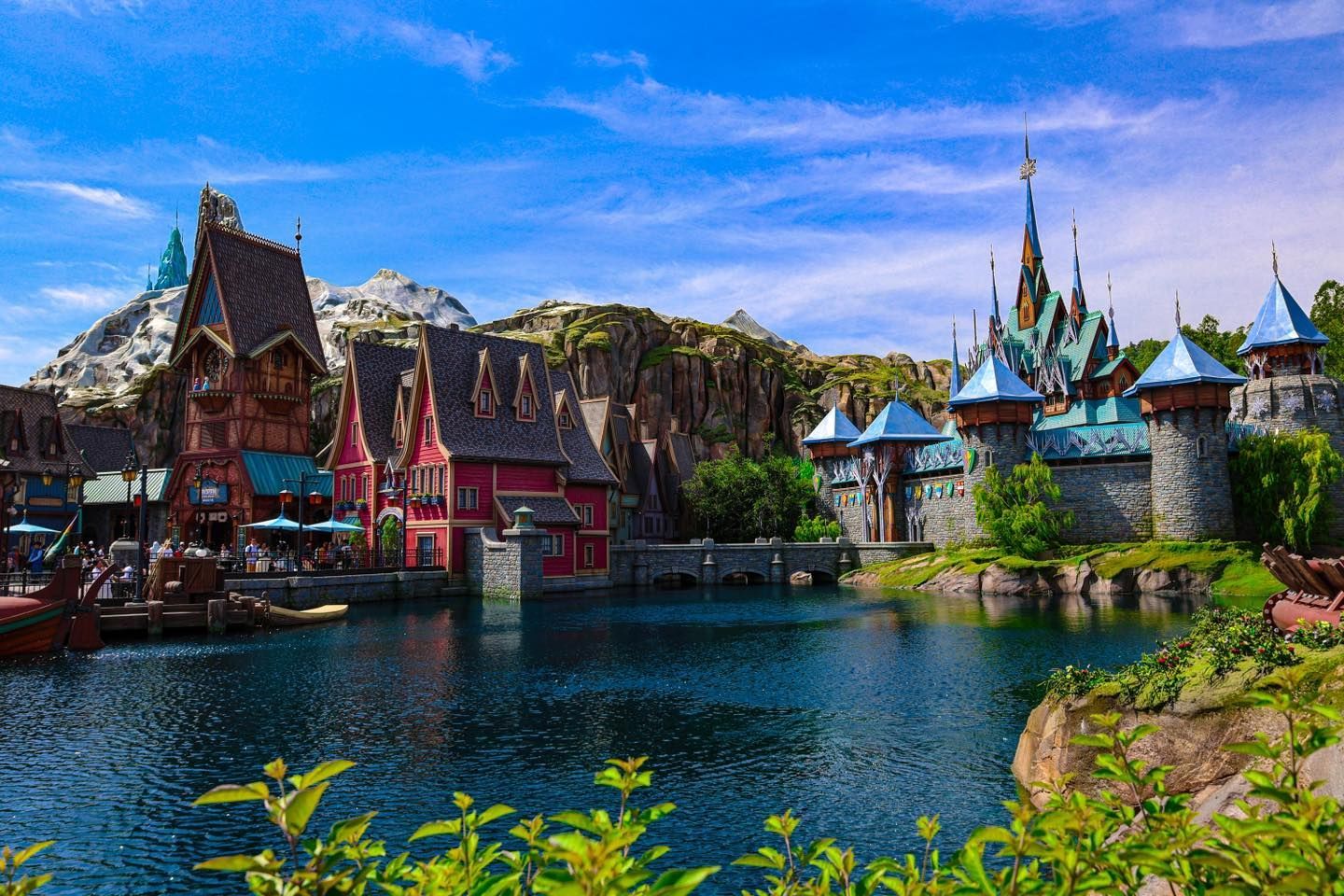 There is a castle in the middle of a lake surrounded by buildings.