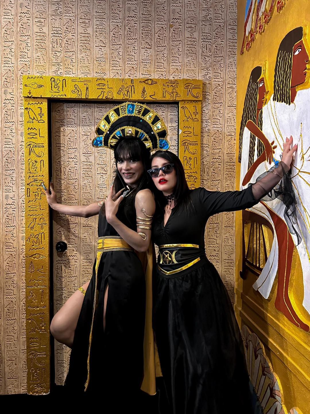 Two women are posing for a picture in front of a door of The Lost Pyramid, 