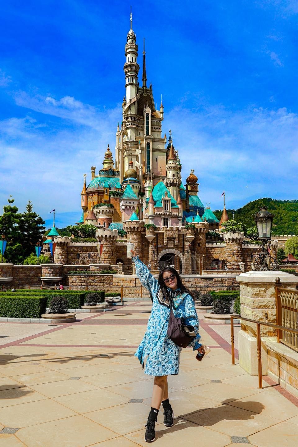 A woman is standing in front of a large castle.