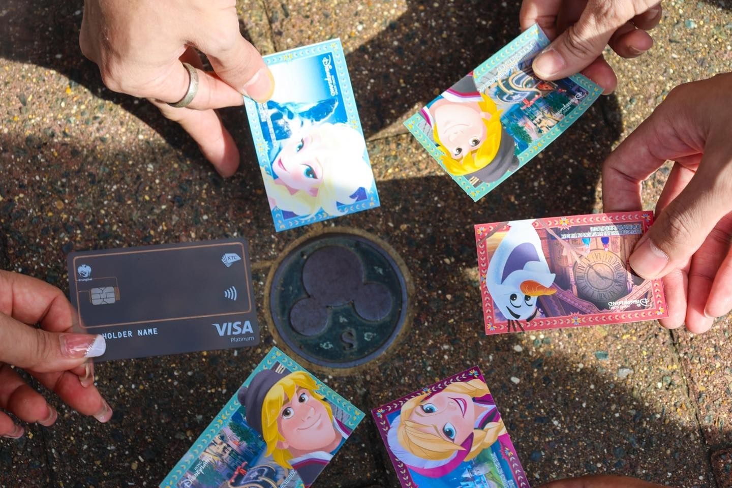 A group of people are holding up frozen credit cards