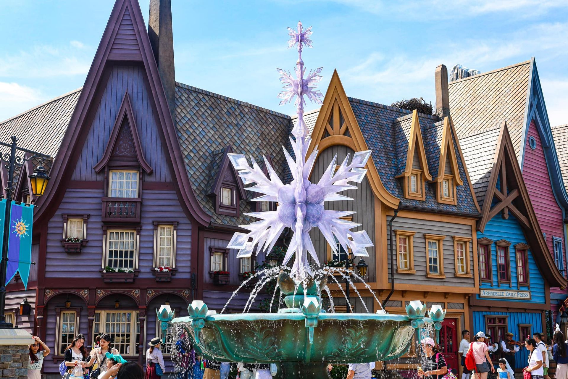 A fountain in front of a row of houses with a snowflake on top of it.