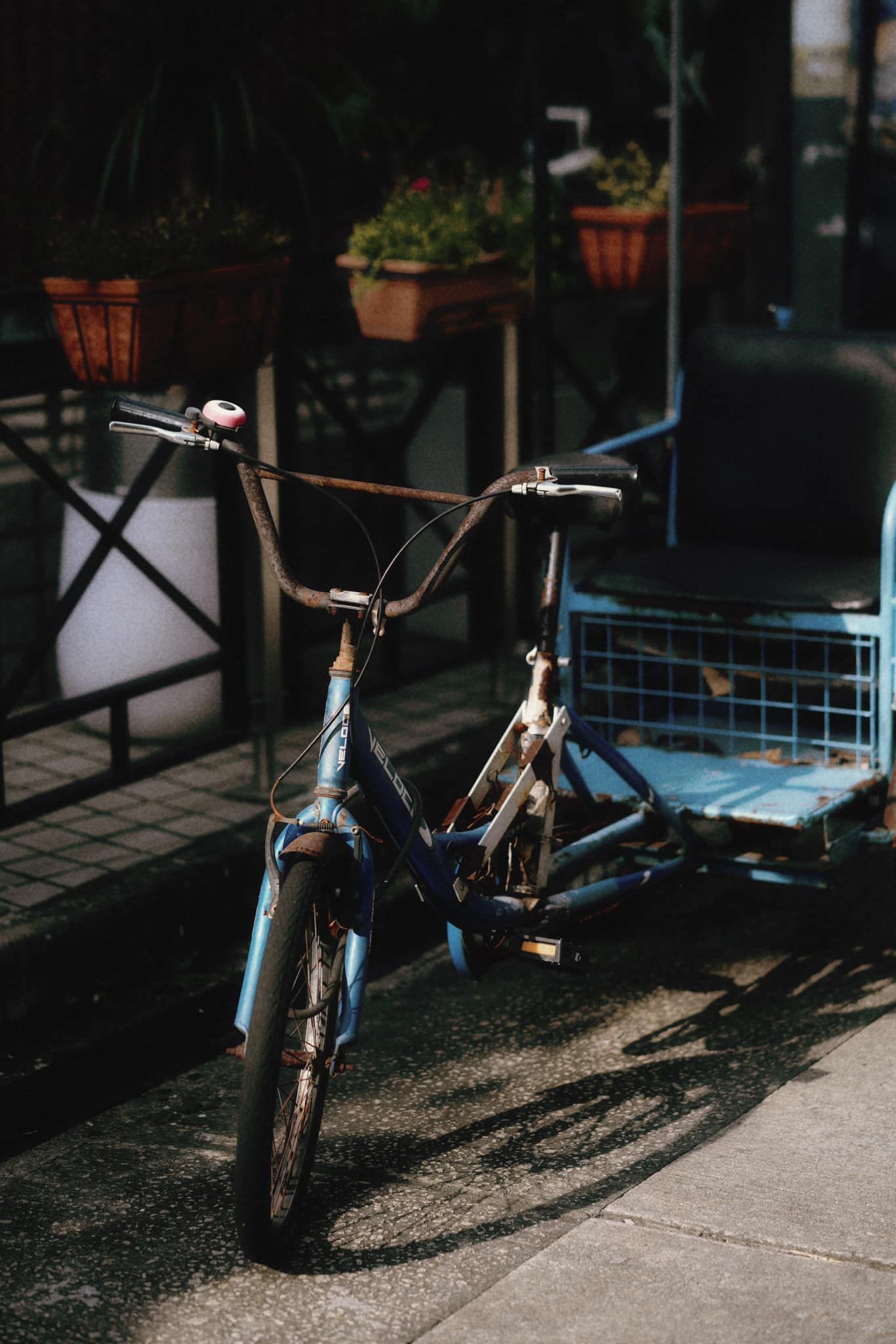 A blue bicycle is parked on the side of the road.