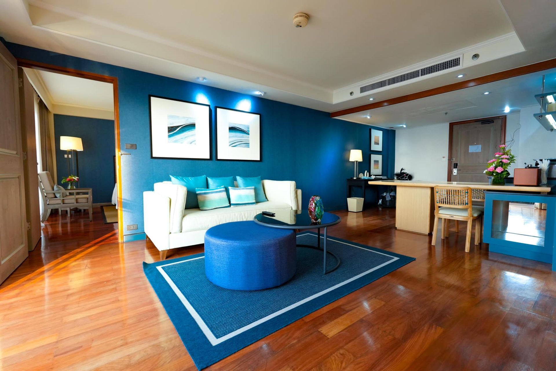A living room with blue walls and a blue ottoman