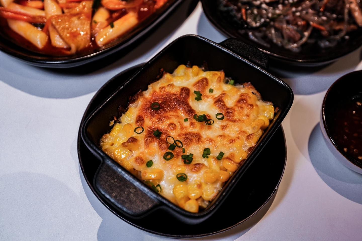 A casserole dish filled with corn and cheese on a table.
