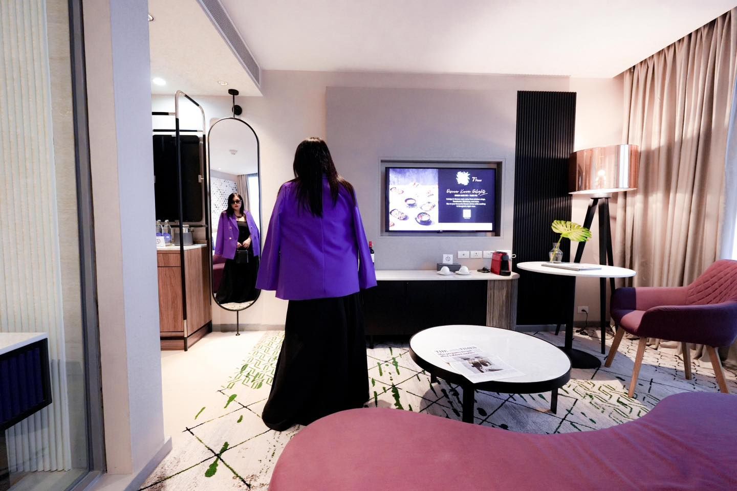 A woman in a purple shirt is standing in a living room in Avani Sukhumvit Bangkok