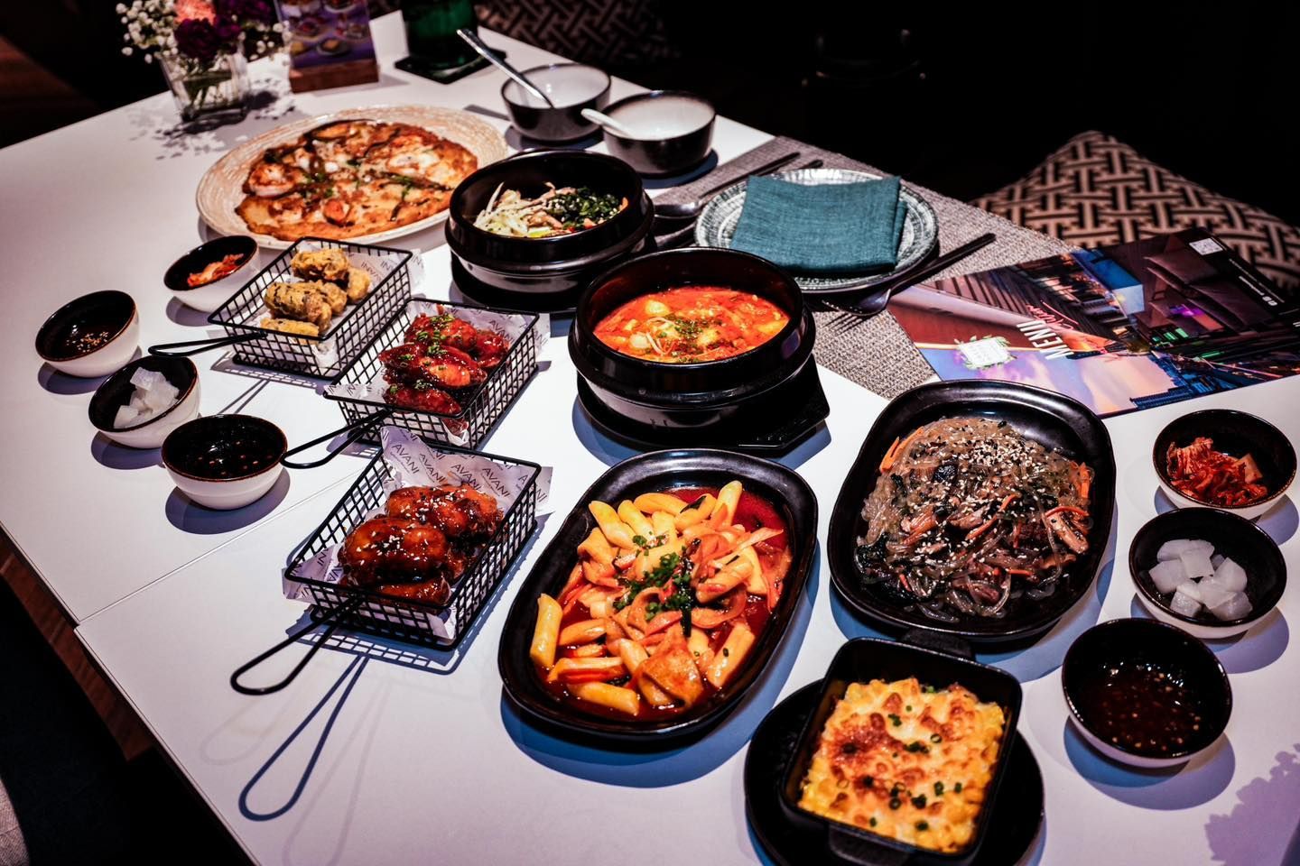 A table topped with plates of food and bowls of sauce.