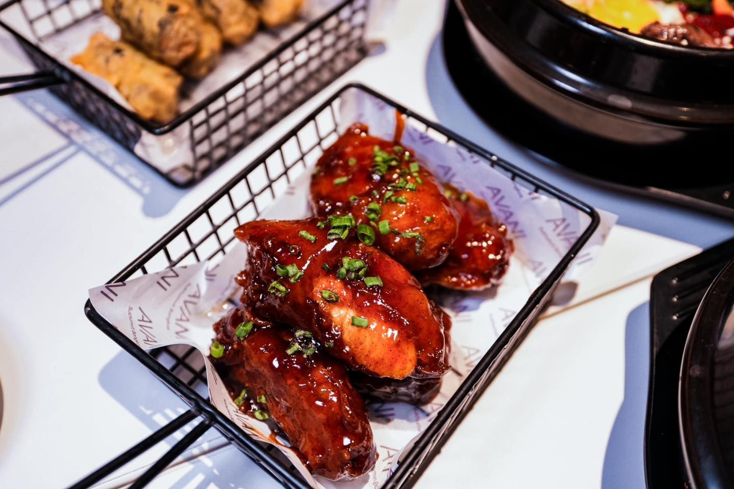 A close up of a plate of chicken wings on a table.