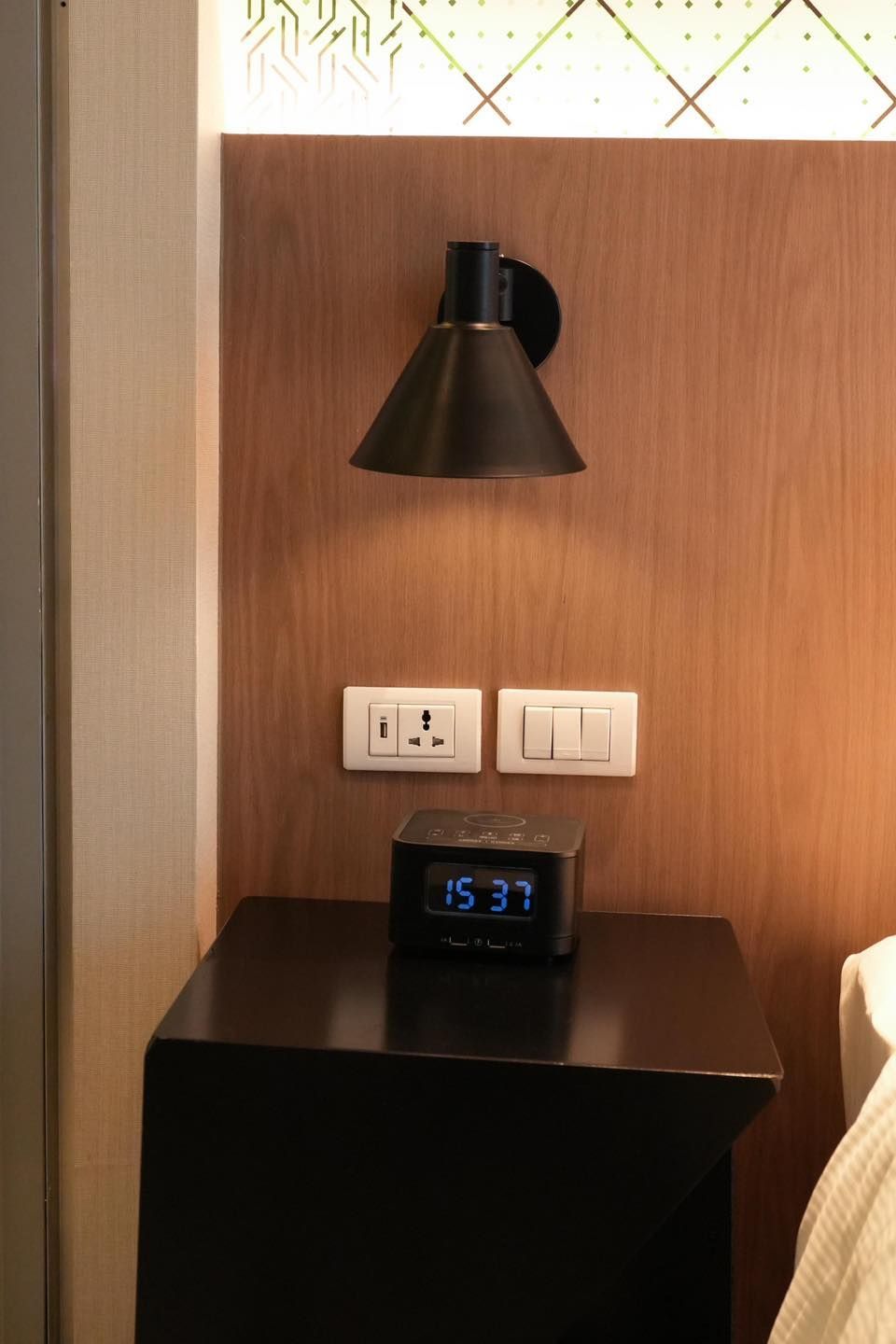 A nightstand with a clock and a lamp on it