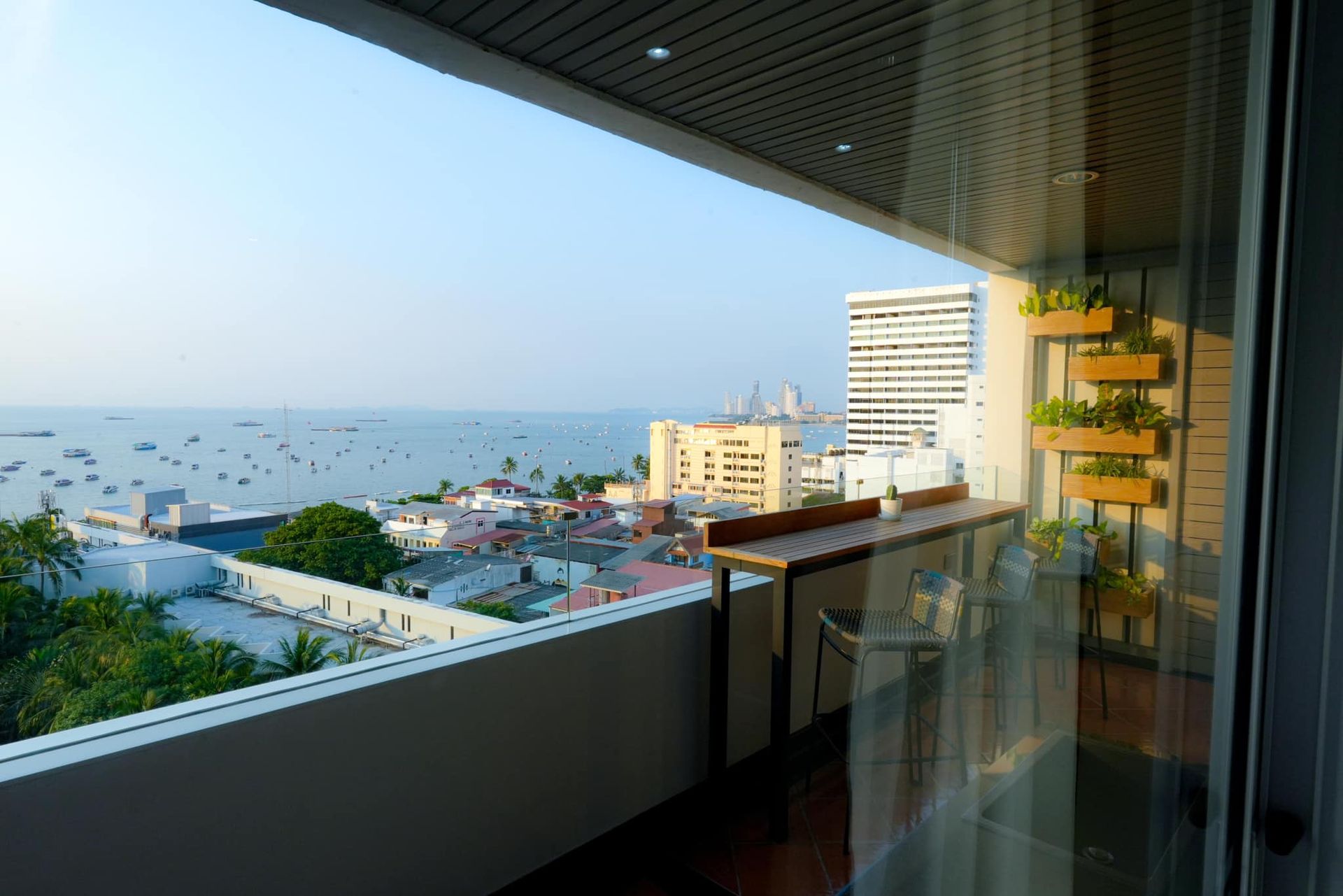 A balcony with a view of the ocean and a city of Pattaya.