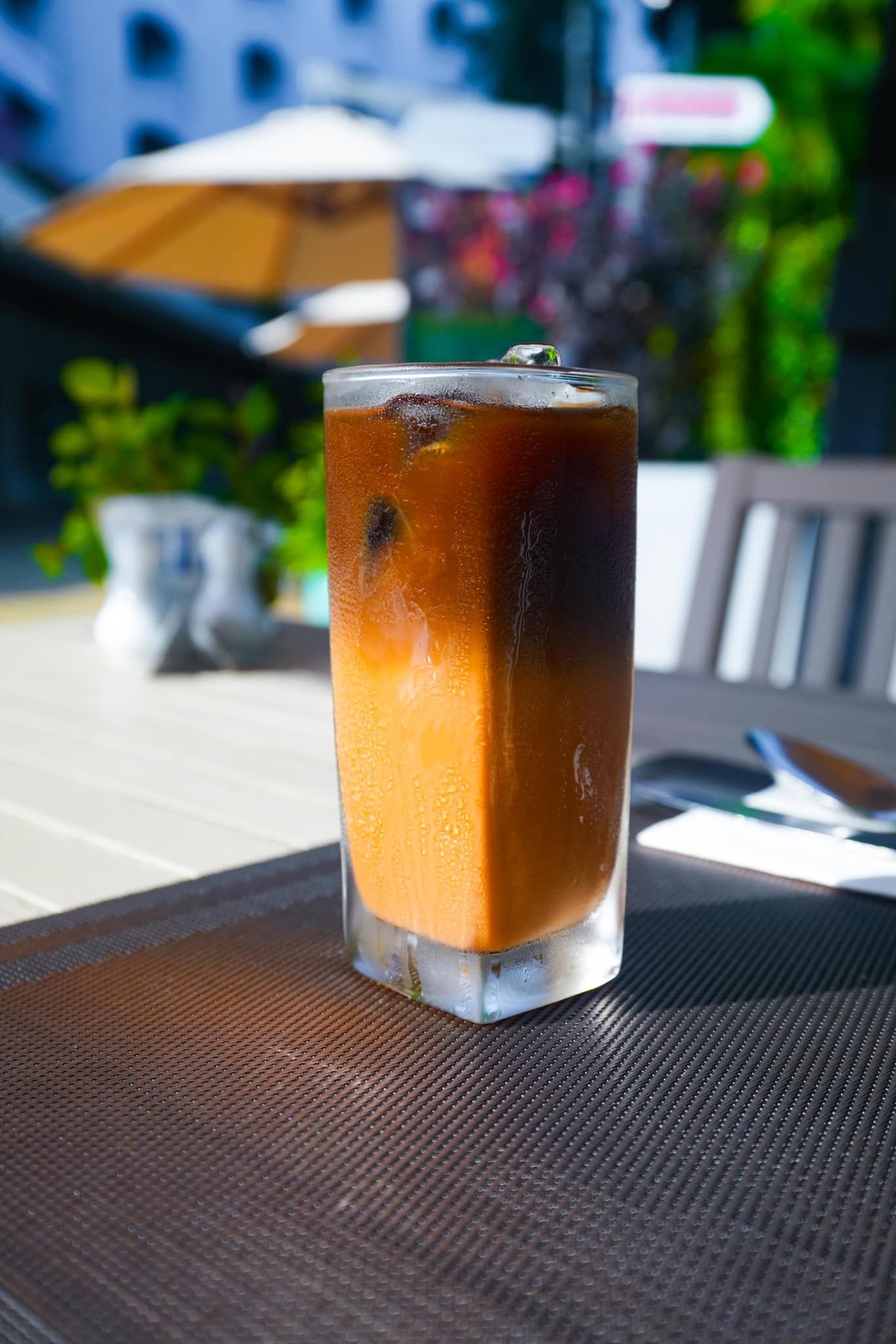 A glass of iced coffee is sitting on a table.