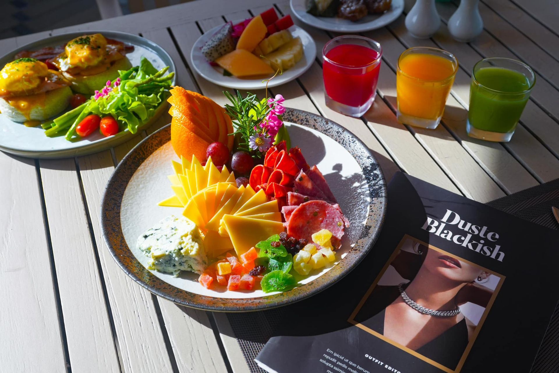 A table topped with plates of food and drinks and a book titled dusty blackish