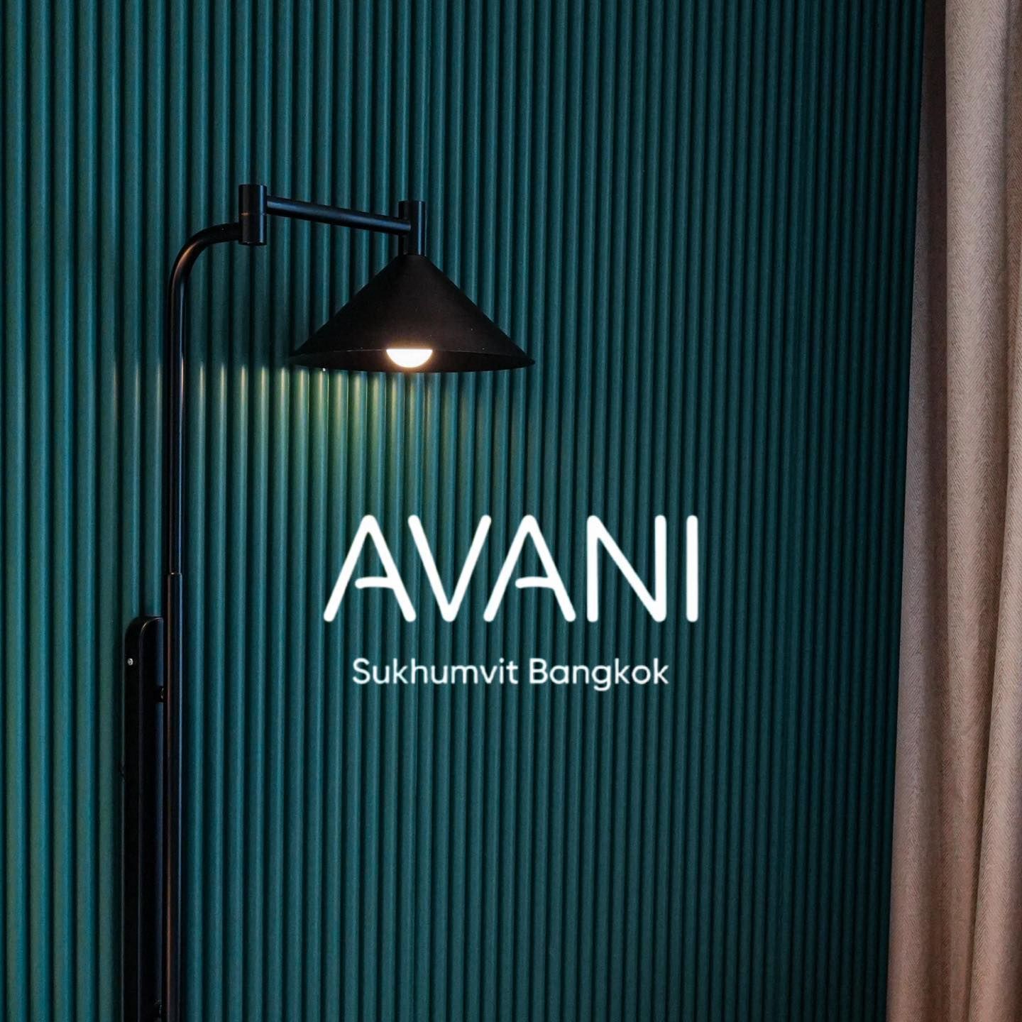 A lamp is sitting in front of a green wall.