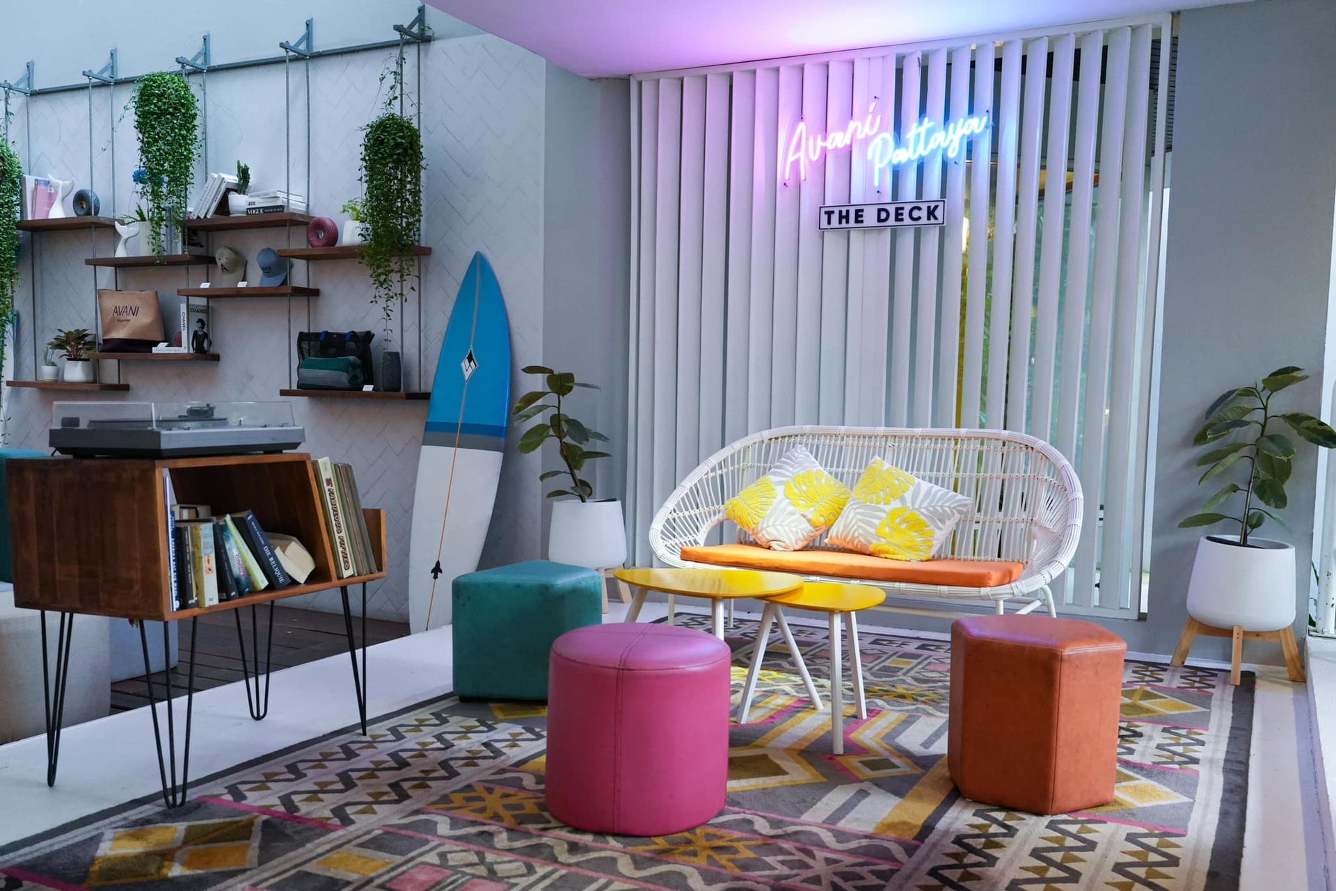 A living room with a couch , ottomans , and a record player.