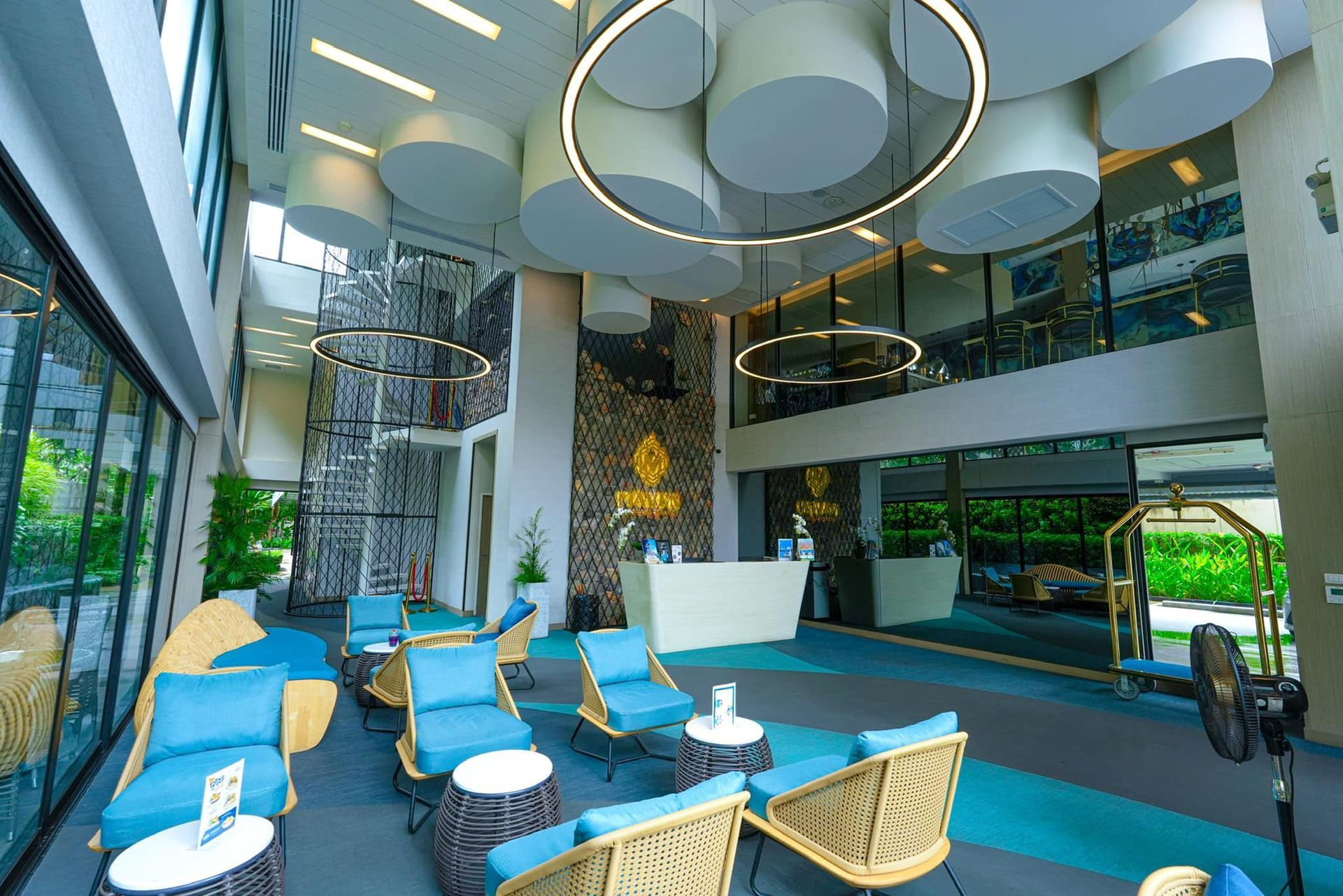 A large lobby of a hotel with lots of chairs and tables.