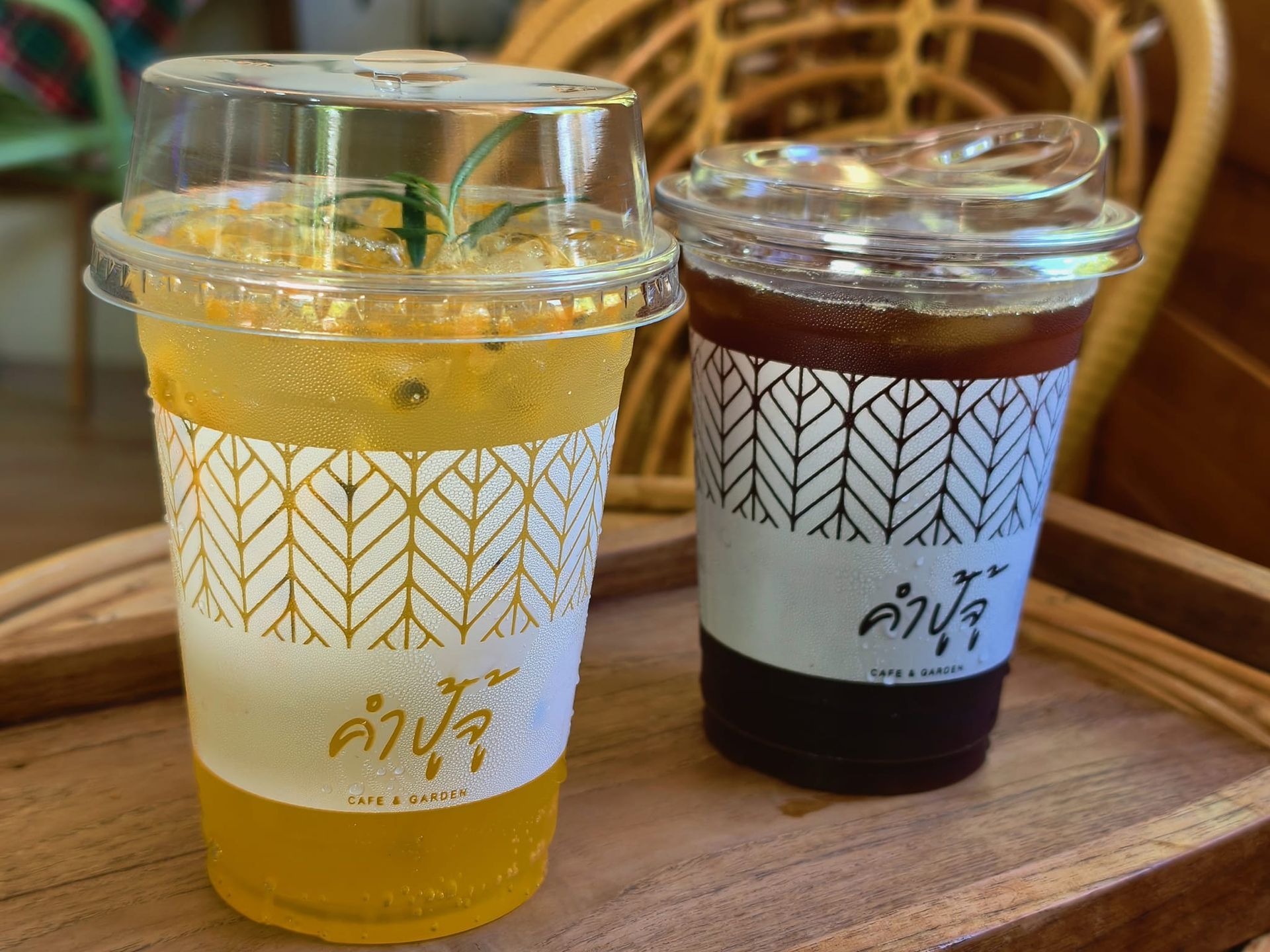 Two cups of drinks are sitting on a wooden table.