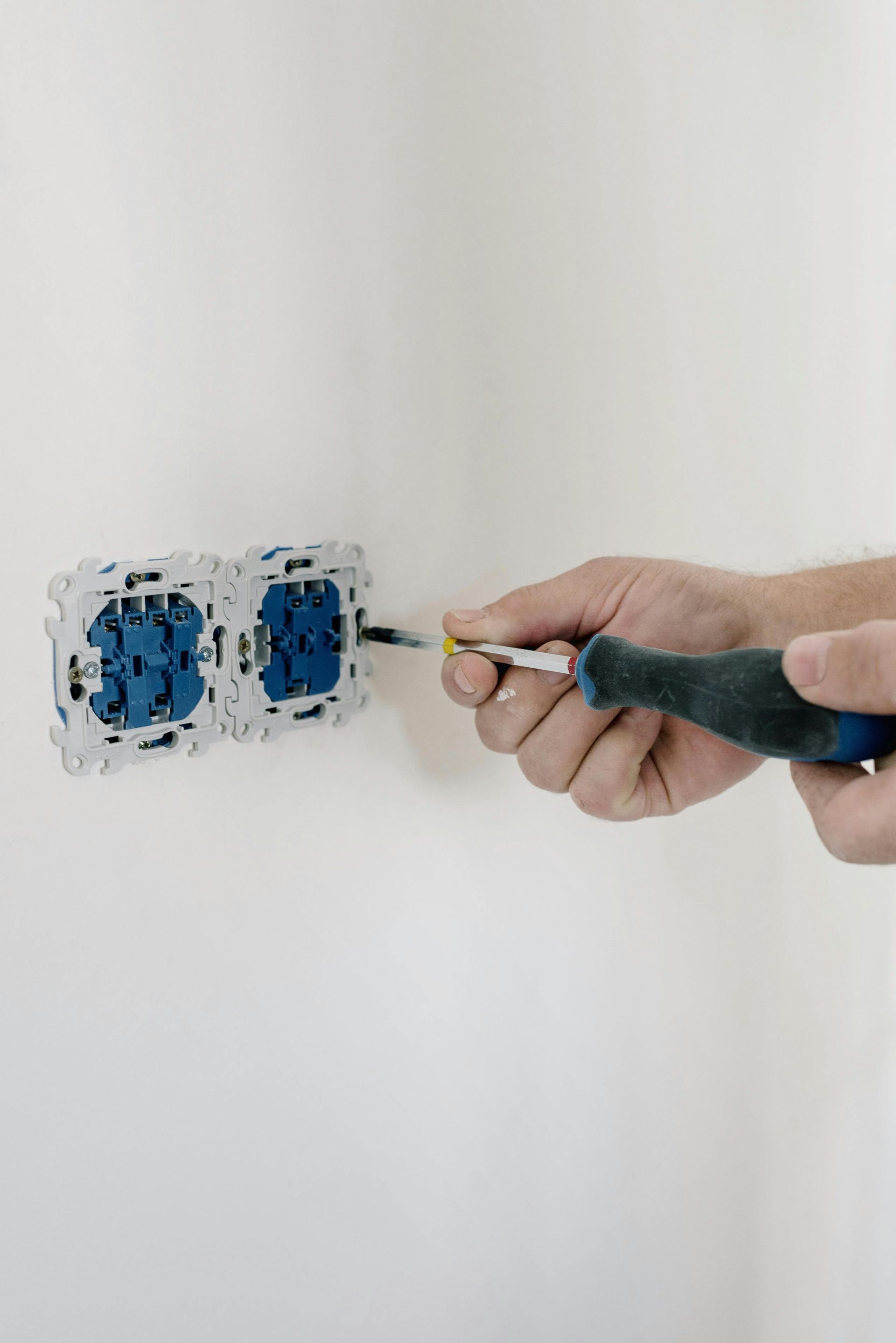 A wall outlet is getting repaired by a professional.