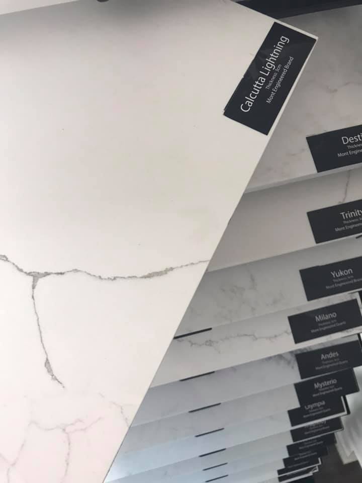 White countertop samples with gray veining and black product labels.