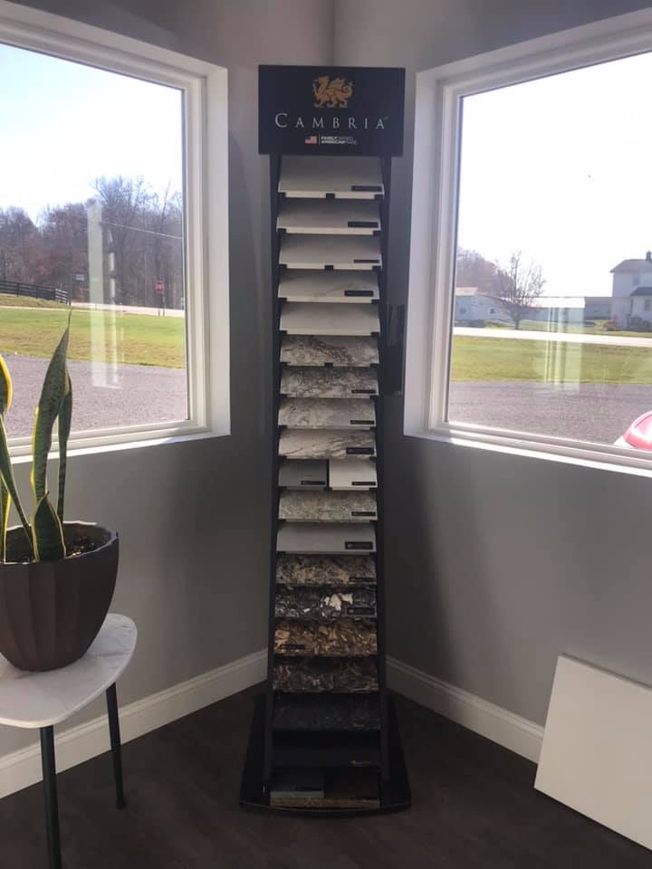 Stone sample display stand between two windows in a room. Samples show different colors and textures.
